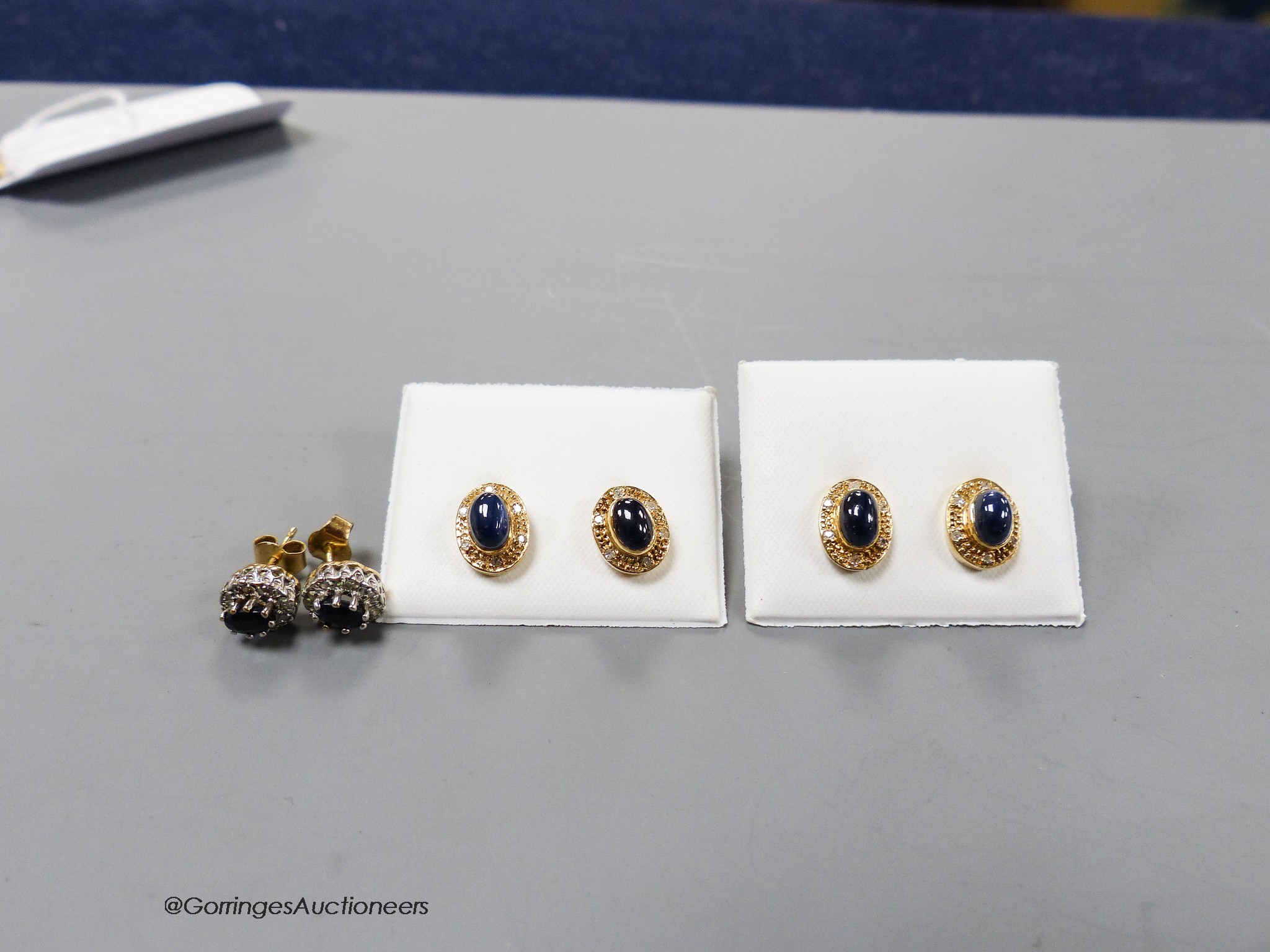 Three modern pairs of 9ct and gem set ear studs, including cabochon blue stone and diamond chip.